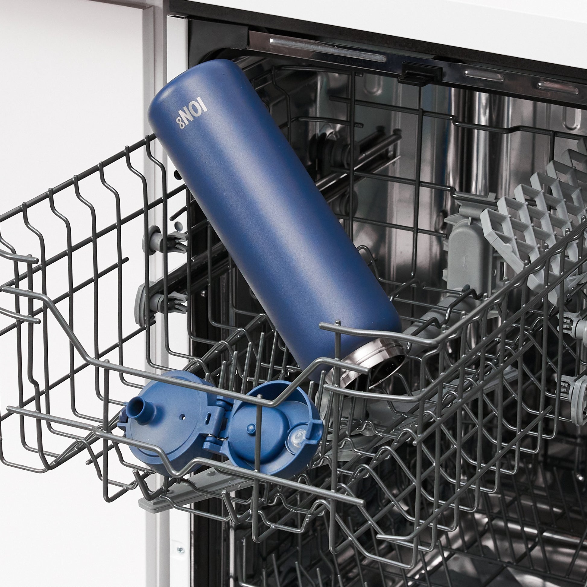 A blue ION8 thermos is being cleaned inside a dishwasher's top rack, along with its lid.