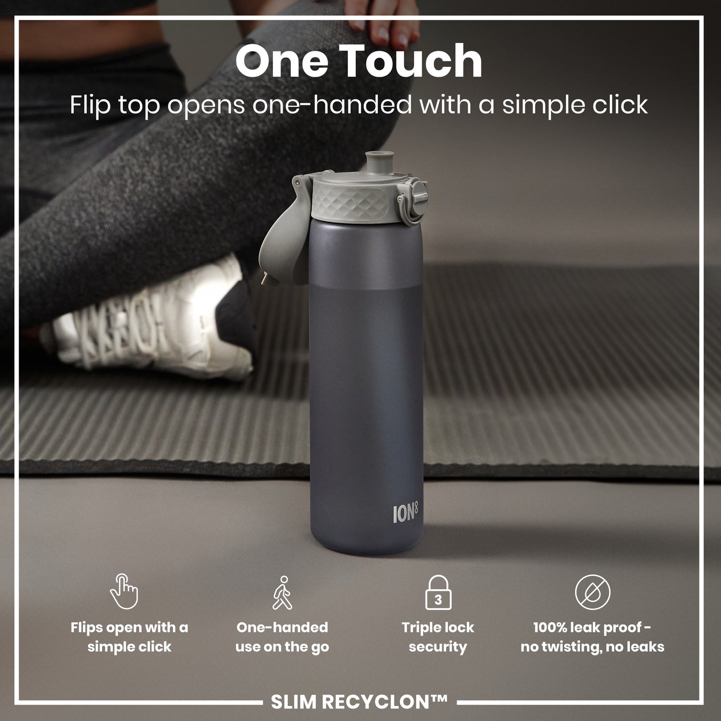 A dark-grey water bottle sits on a yoga mat; its flip top opens one-handed. The bottle is marketed as “One Touch,” “one-handed use,” “triple lock security,” and “100% leak proof.” SLIM RECYCLON™ is also noted.