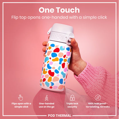 A colorful, patterned water bottle is being held; its flip top opens one-handed. The bottle is shown against a pink background.