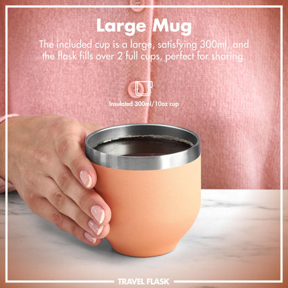 A hand holds an insulated 300ml/10oz cup with a metallic rim on a table against a pink garment background. Text: "Large Mug The included cup is a large, satisfying 300ml, and the flask fills over 2 full cups, perfect for sharing. Insulated 300ml/10oz cup TRAVEL FLASK"