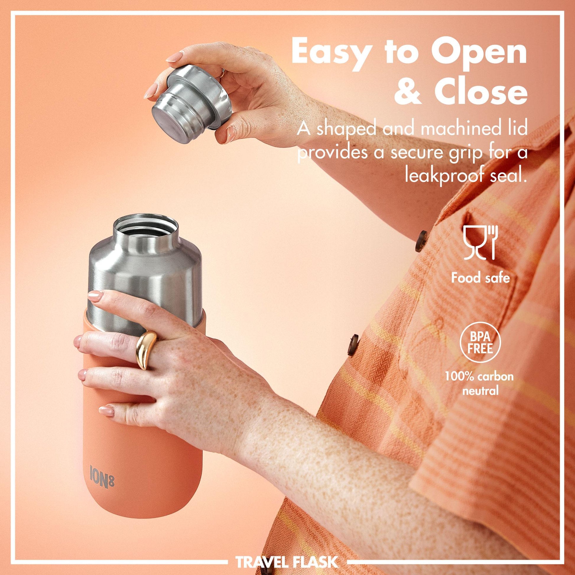 Hands unscrewing a metal lid from an orange travel flask against a peach background Text reads Easy to Open & Close A shaped and machined lid provides a secure grip for a leakproof seal Food safe BPA free 100% carbon neutral TRAVEL FLASK