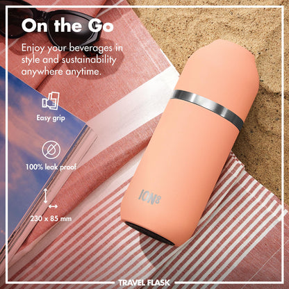 A peach-colored travel flask lies on a striped cloth beside sunglasses and a magazine on the sand. Text reads "On the Go," "Enjoy your beverages in style and sustainability anywhere anytime," "Easy grip," "100% leak proof," "230 x 85 mm," "ION8," "TRAVEL FLASK."