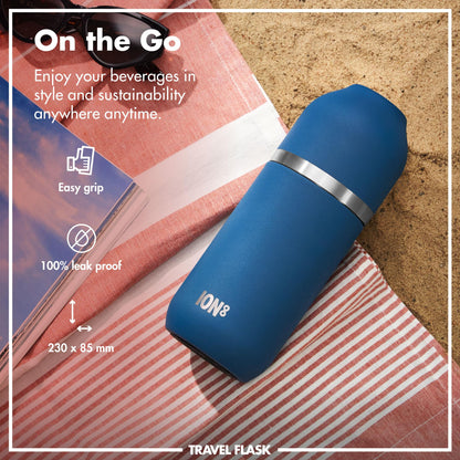 A blue travel flask labeled "ION8" rests on a striped towel beside a book and sunglasses on sand. Text reads: "On the Go Enjoy your beverages in style and sustainability anywhere anytime. Easy grip 100% leak proof 230 x 85 mm" "TRAVEL FLASK".