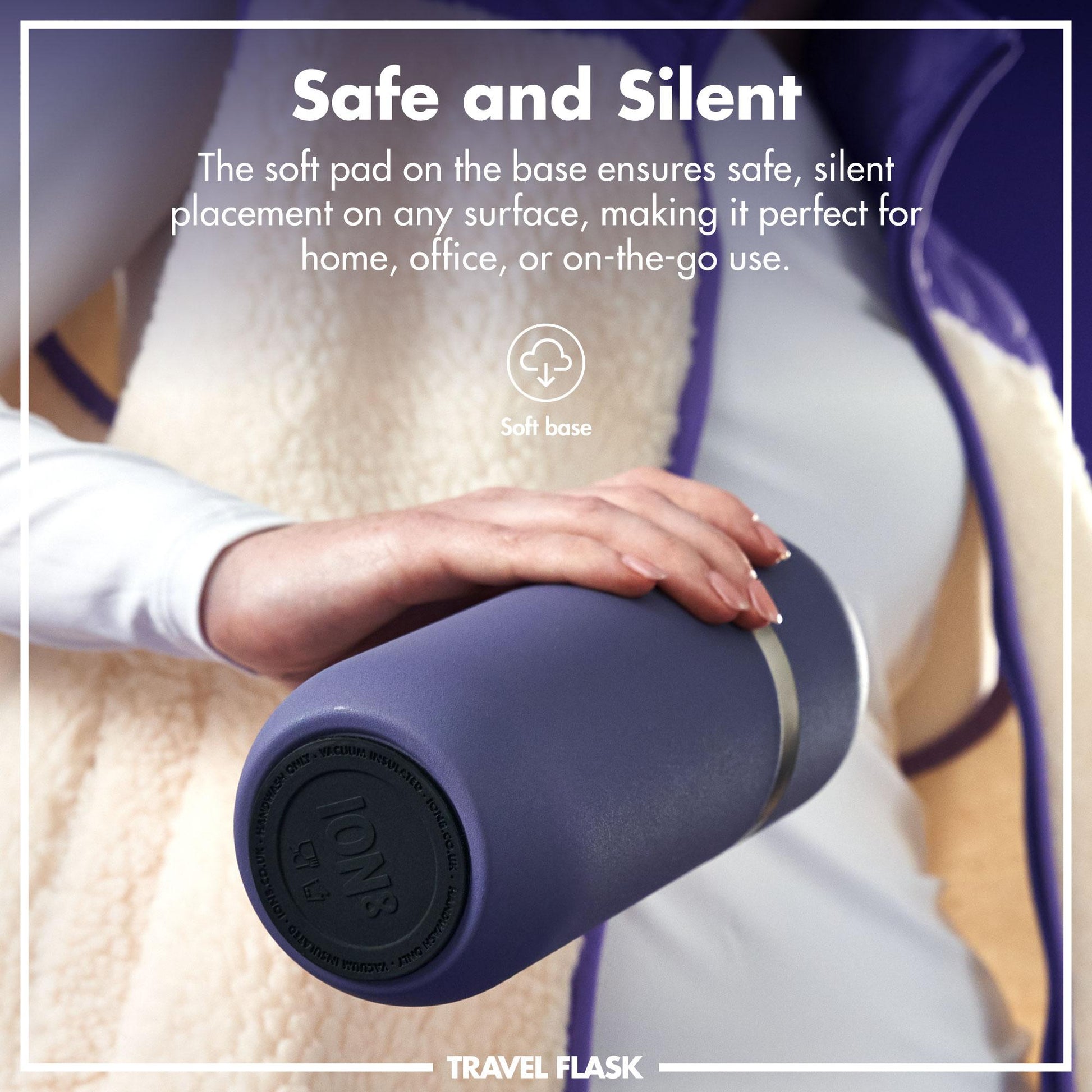 A hand gently holds a blue travel flask with a soft base against a cozy, fleece background. Text reads Safe and Silent The soft pad on the base ensures safe, silent placement on any surface, making it perfect for home, office, or on-the-go use. Soft base TRAVEL FLASK